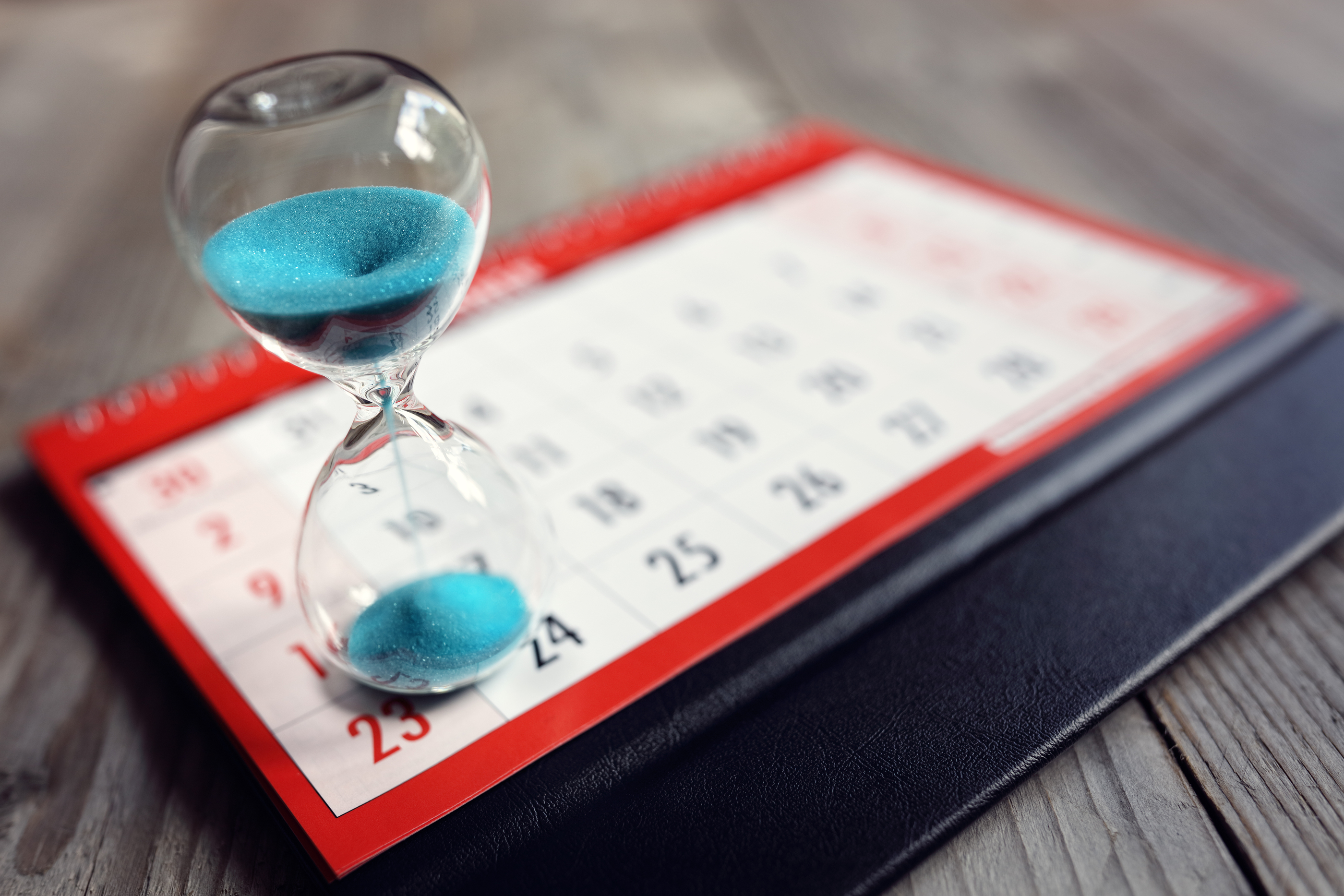 Hour glass on calendar concept for time slipping away for import